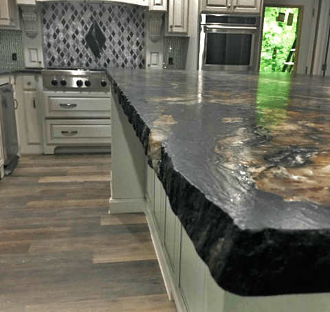 A kitchen with a large granite counter top and a stove.