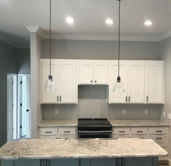 A kitchen with white cabinets and granite counter tops