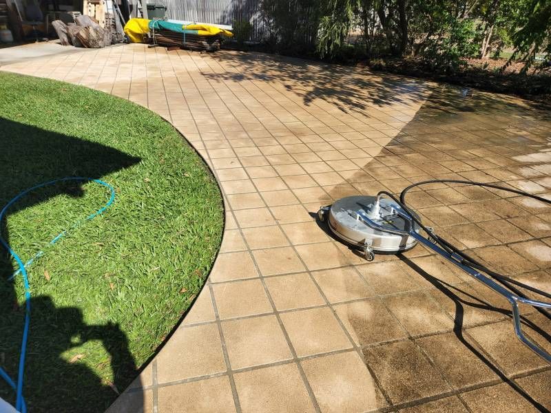 A Person Pressure Washing a Stone Patio, Half Cleaned and Half Dirty — Carpet 2 Couch In Condon, QLD