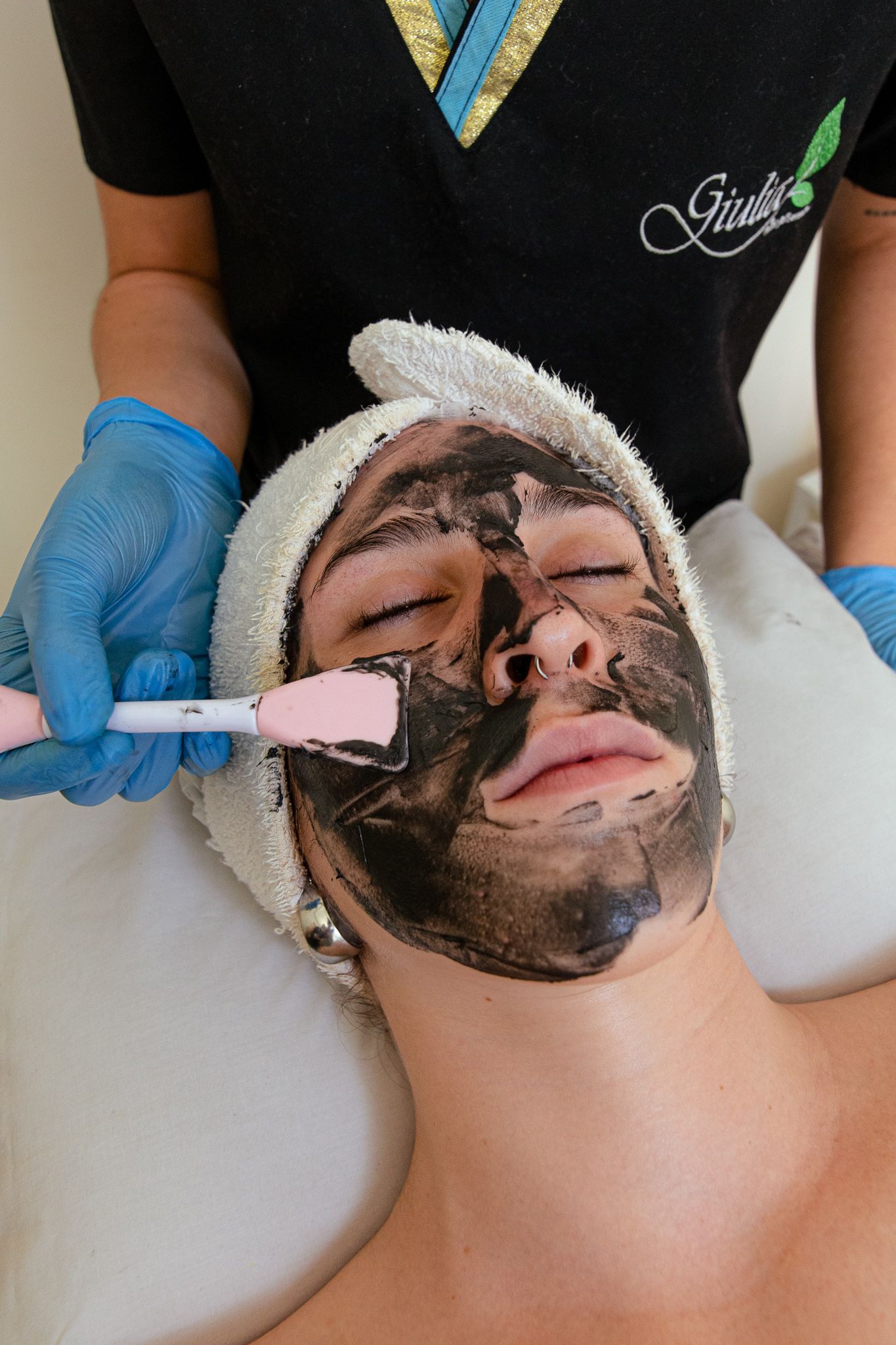 Persona recibiendo un tratamiento con mascarilla facial de luz azul en un entorno de spa.