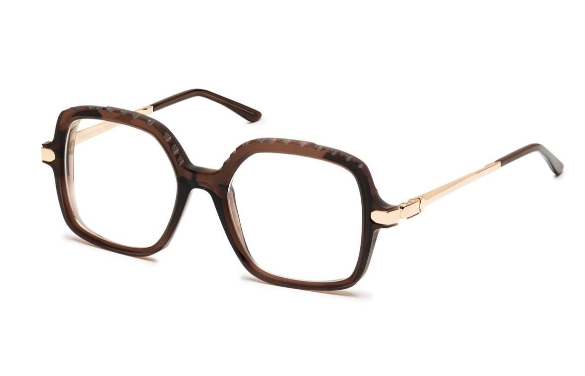 Lunettes à monture noire, branches et cercles à motifs sur fond blanc.