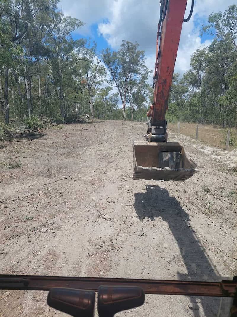A Bulldozer is Moving Dirt on a Dirt Road — B E Laser Levelling QLD in Bucca, QLD
