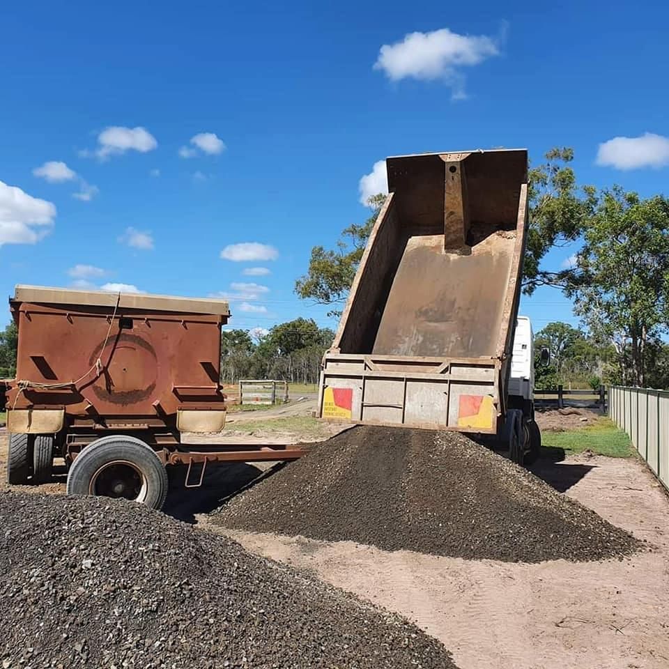 A Dump Truck is Dumping Dirt Into a Pile — B E Laser Levelling QLD in Bucca, QLD