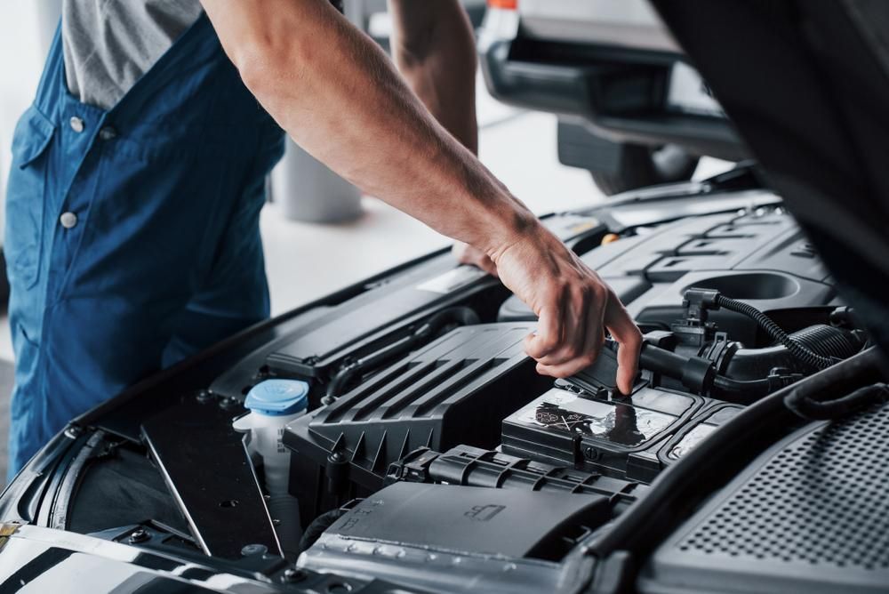 A Man Is Working On The Engine Of A Car With The Hood Open — Dancers Car Care In Ballina, NSW