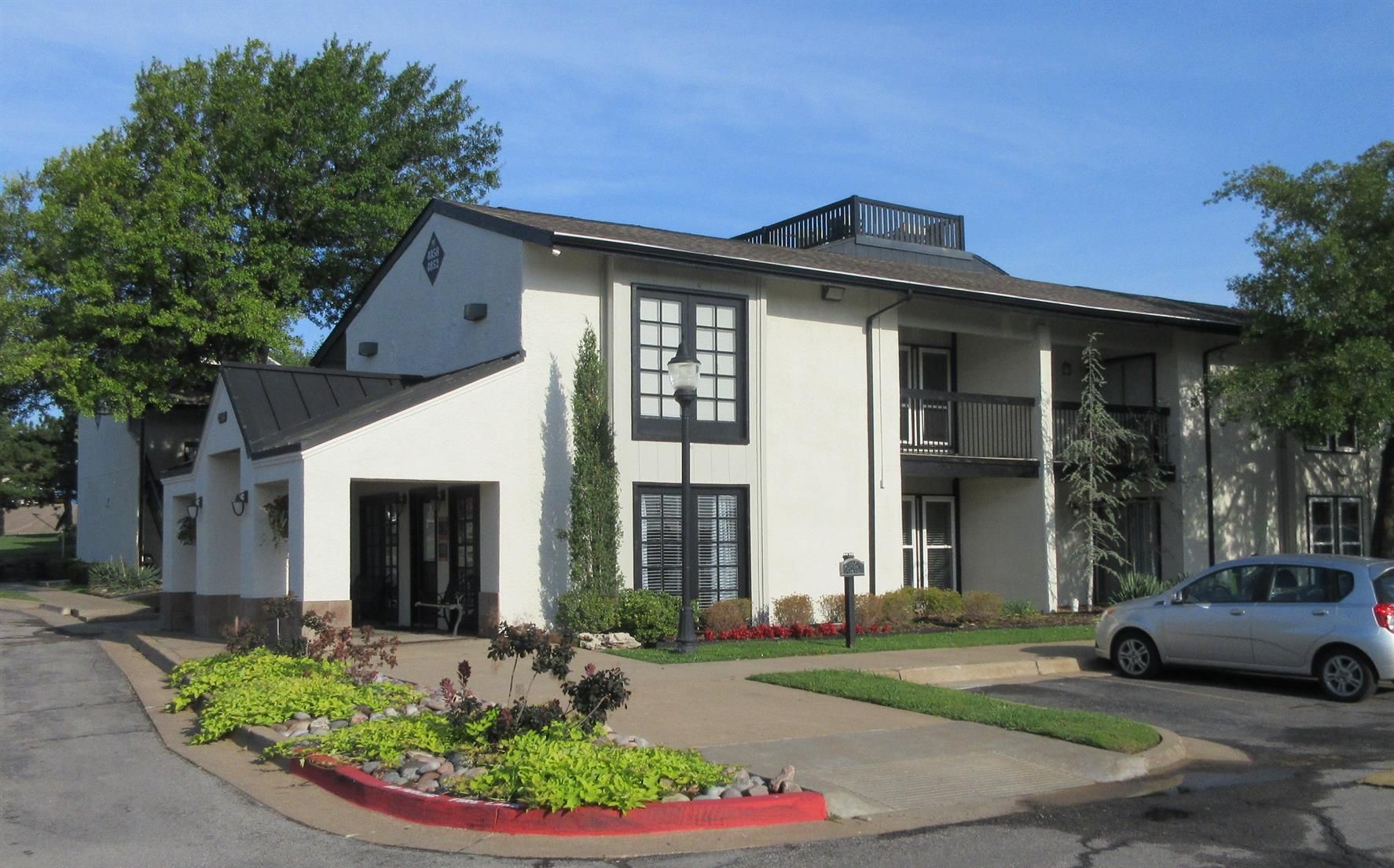 A white building with a car parked in front of it