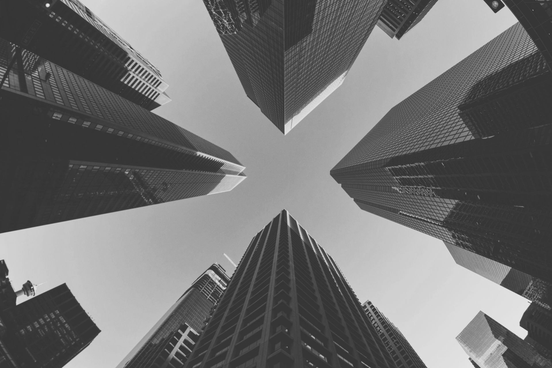 Black and white shot looking up at tall skyscrapers against a clear sky.