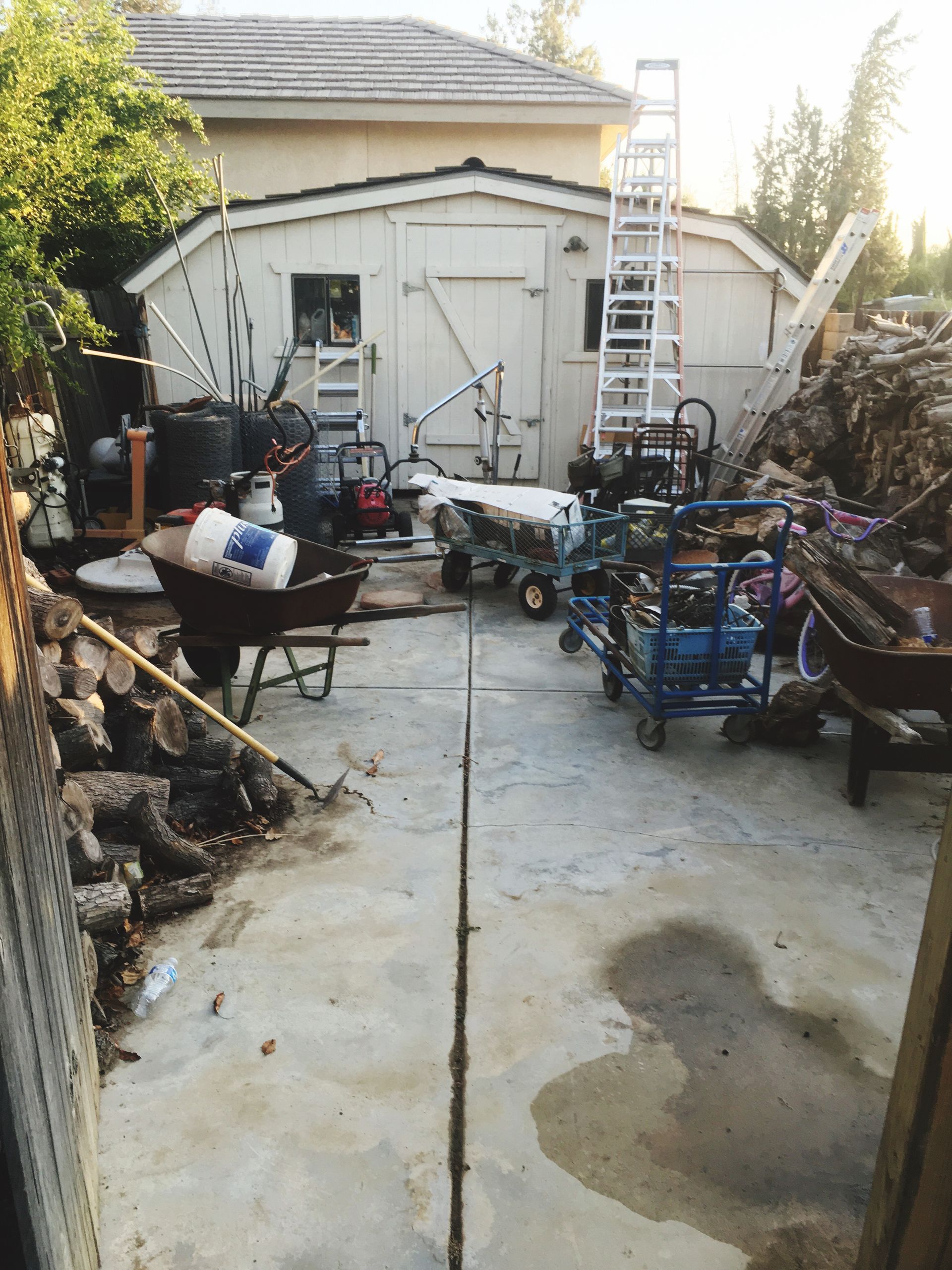 A garage with a lot of tools and a wheelbarrow in front of it