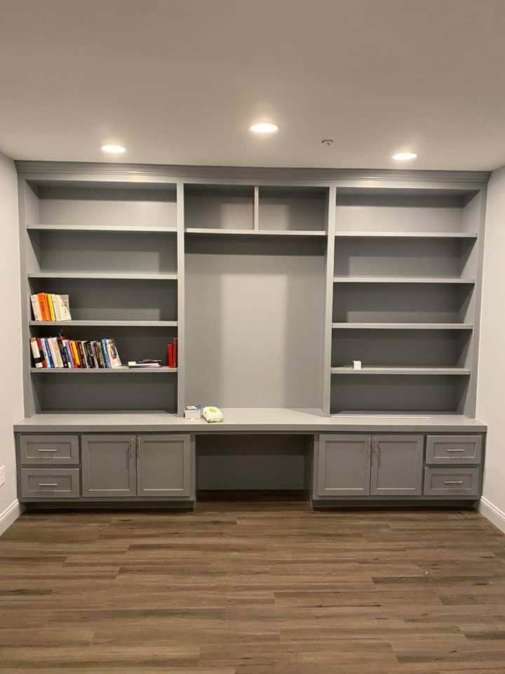 A room with a lot of shelves and a desk.