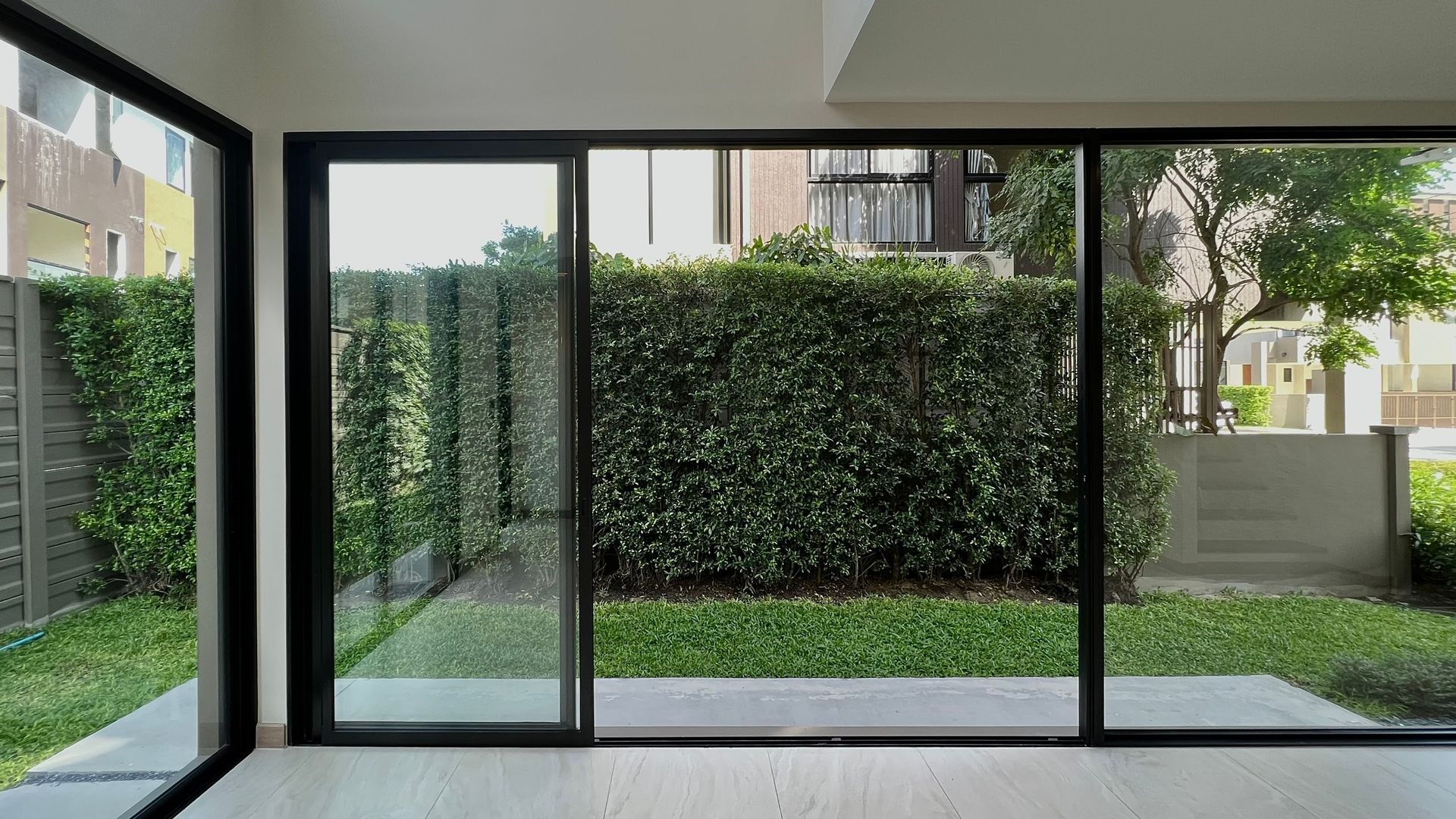 An empty room with sliding glass doors leading to a garden.
