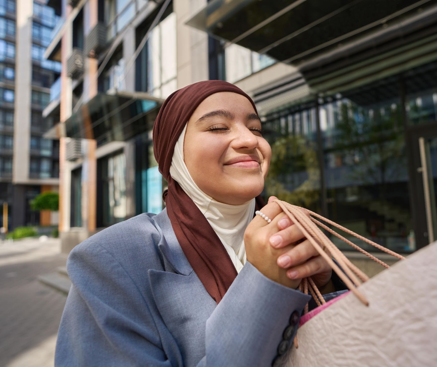 A woman in a yellow jacket is holding a cell phone in her hand.