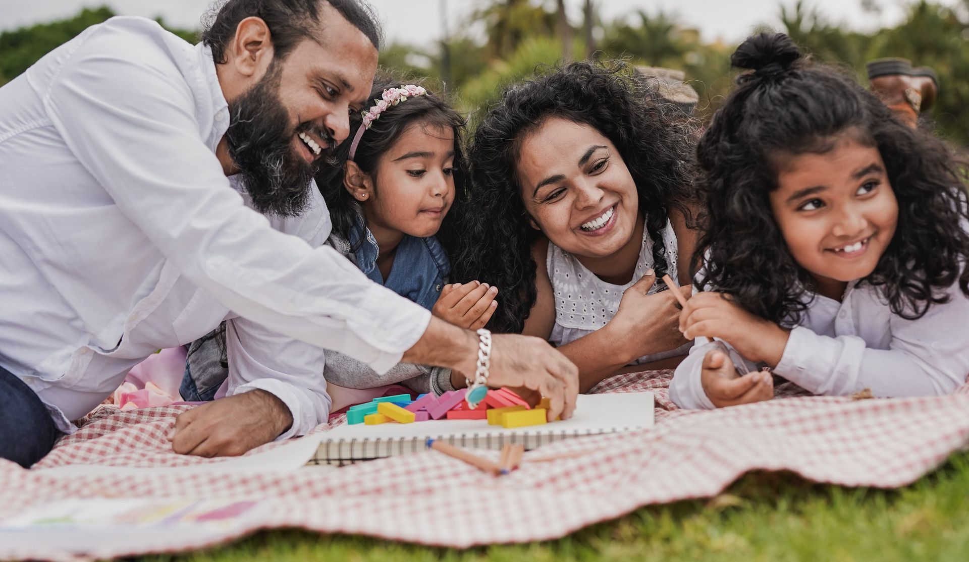 A family is having a picnic in the park and playing with toys.