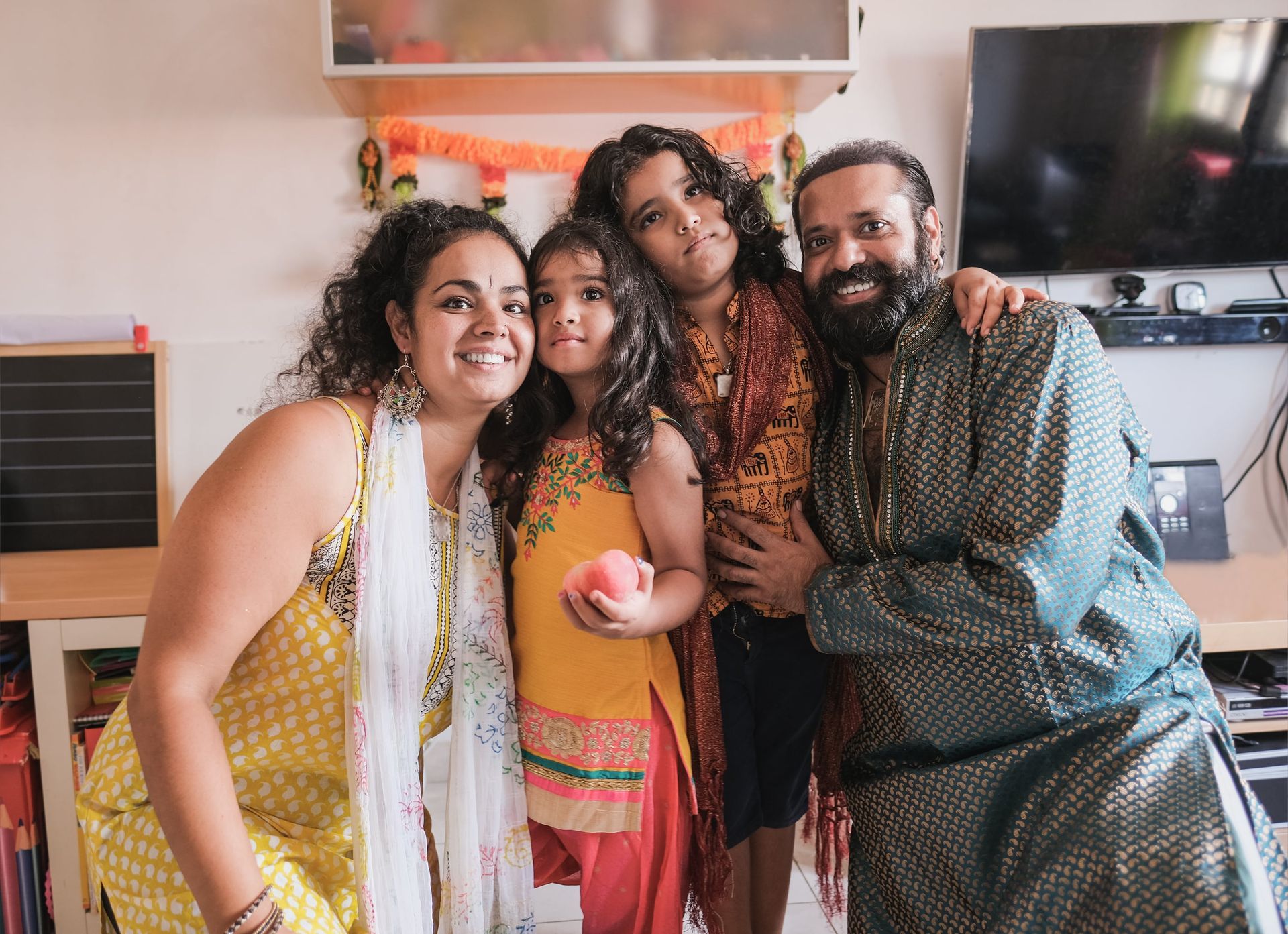 A family is posing for a picture together in a living room.