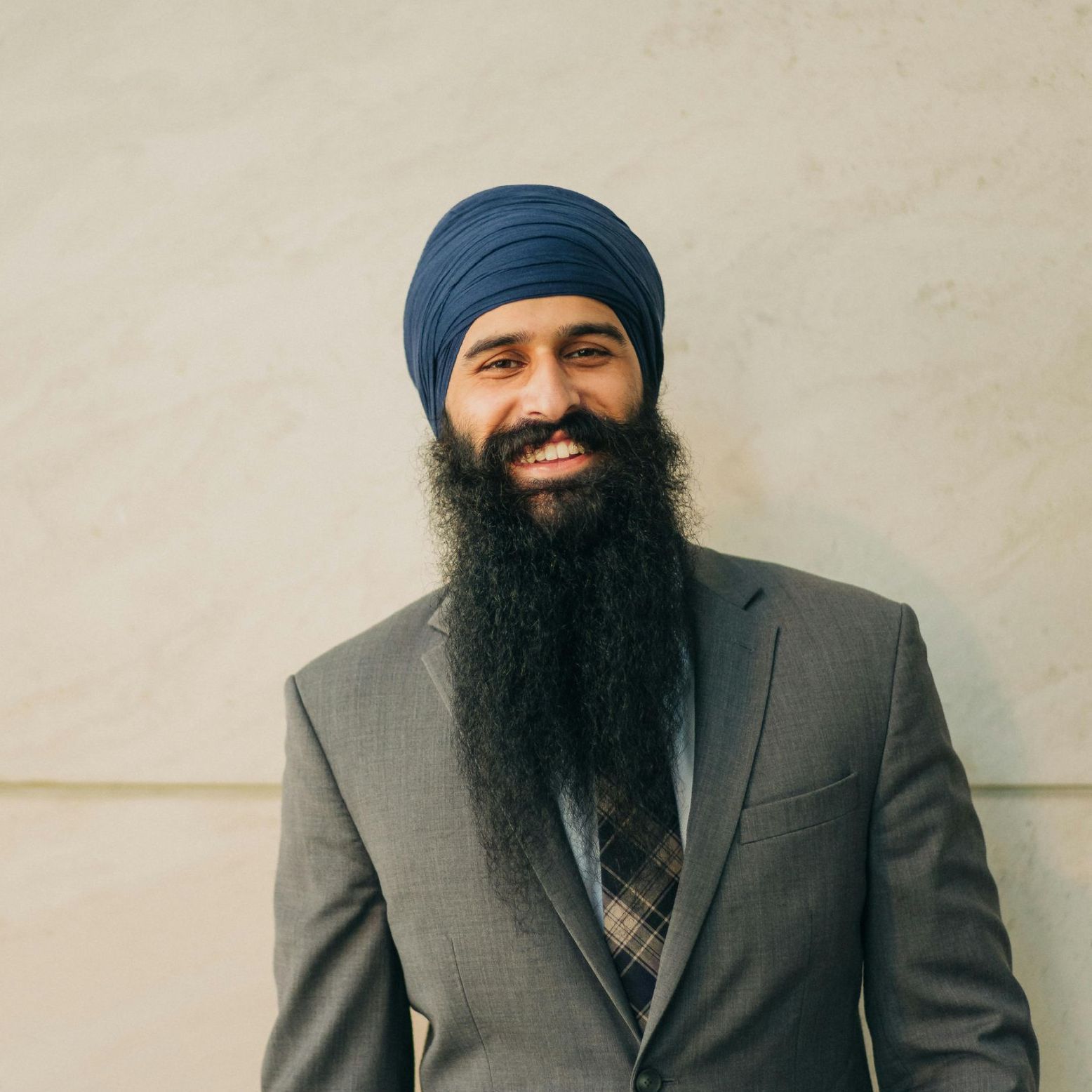 A man with a beard wearing a turban and a suit