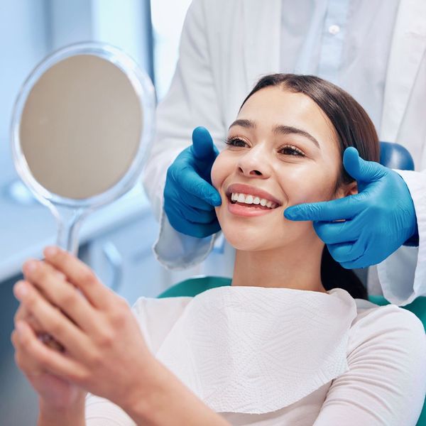 Woman Checking Her Teeth on Mirror — Strathpine, QLD — Northside Family Smile Woman Checking Her Teeth on Mirror — Strathpine, QLD — Northside Family Smile
