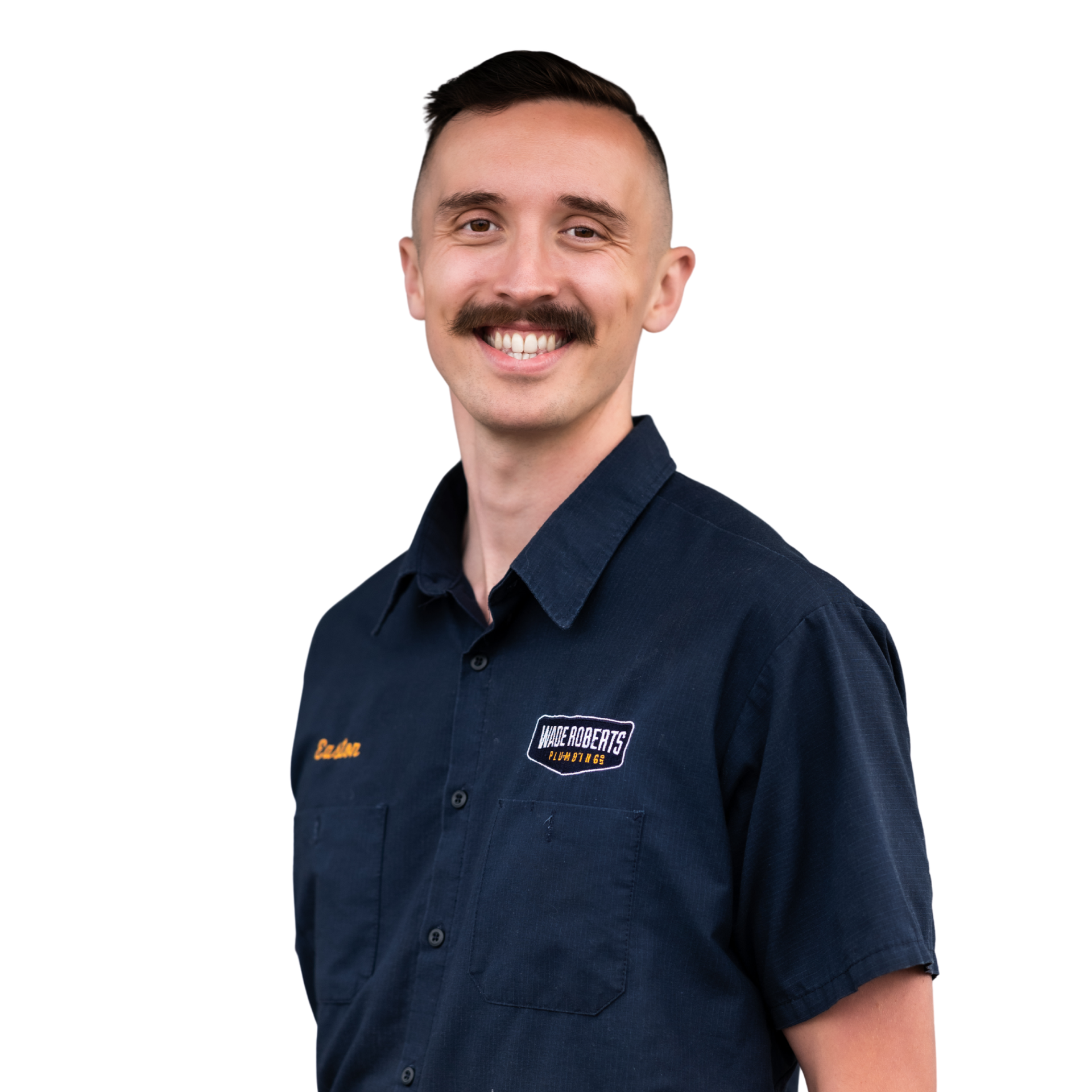 A man in overalls and a hat is holding a wrench.