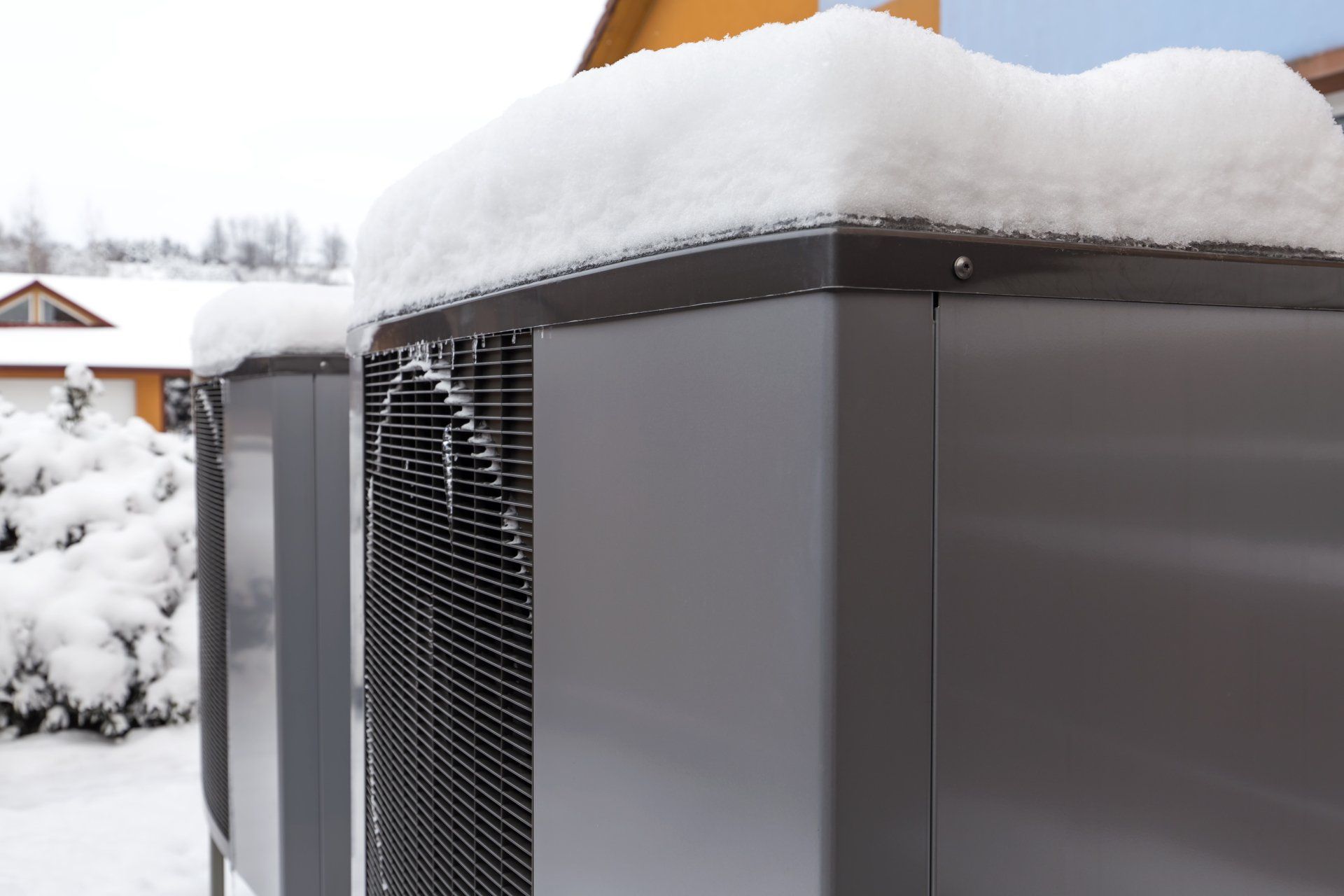 A couple of air conditioners covered in snow.