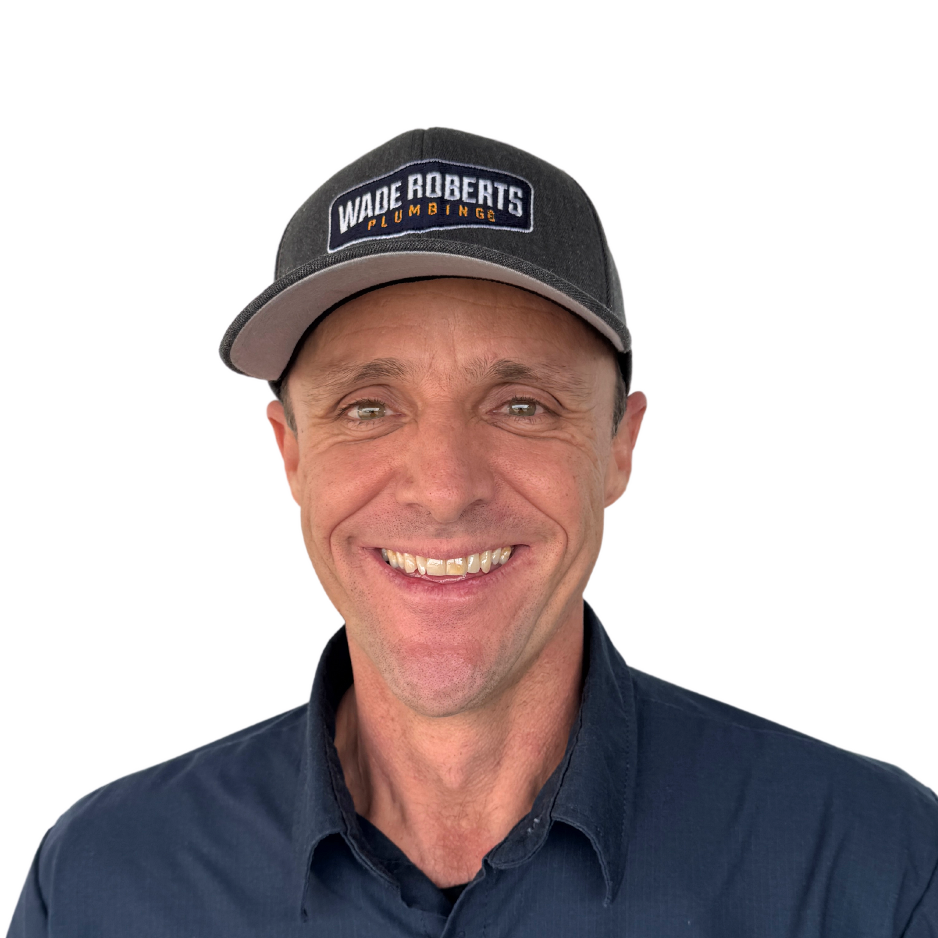 A man wearing a baseball cap and a blue shirt is smiling.