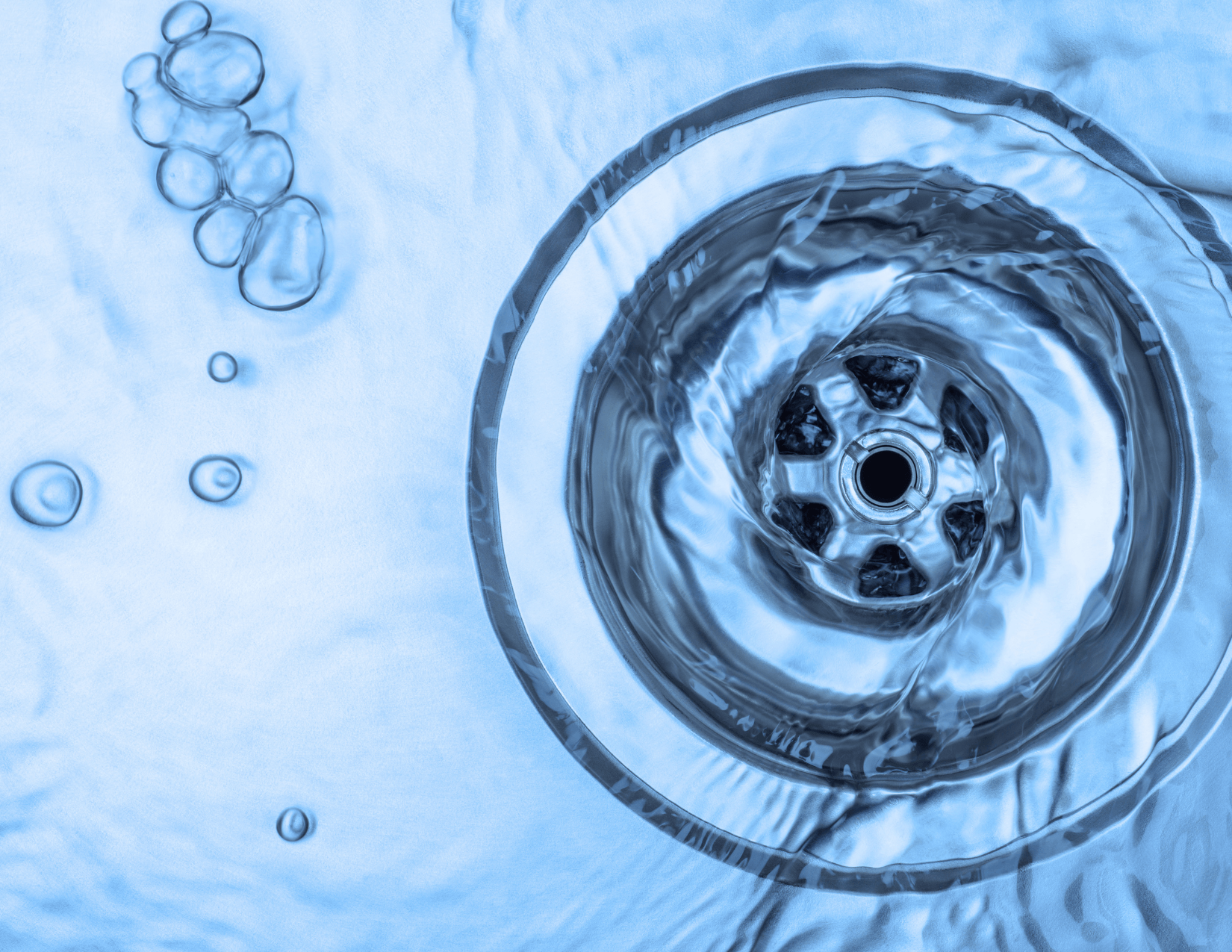 A close up of a sink drain with water running down it.
