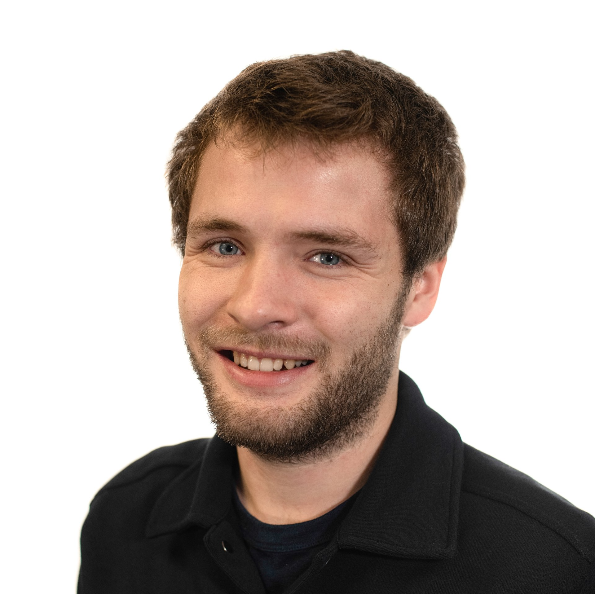 A man with a beard is smiling and wearing a black shirt