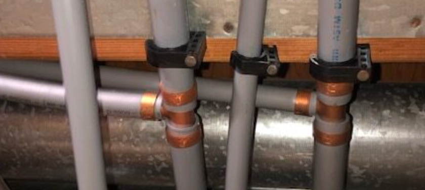 A man is installing underfloor heating pipes on the floor.