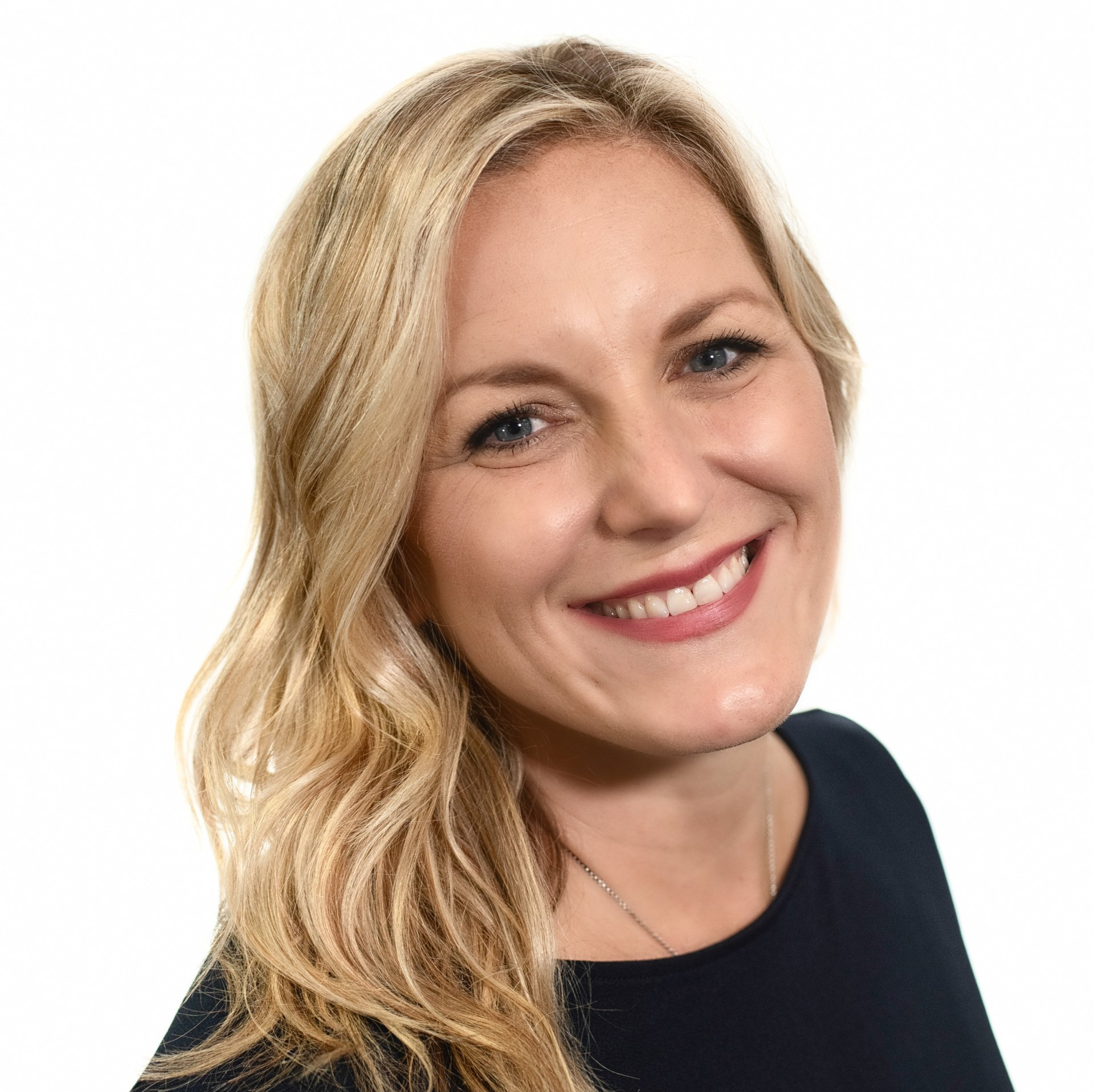 A woman with blonde hair is smiling and wearing a black shirt