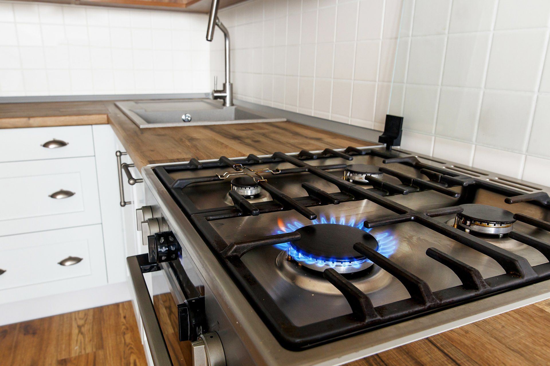 A gas stove with a blue flame on it in a kitchen.