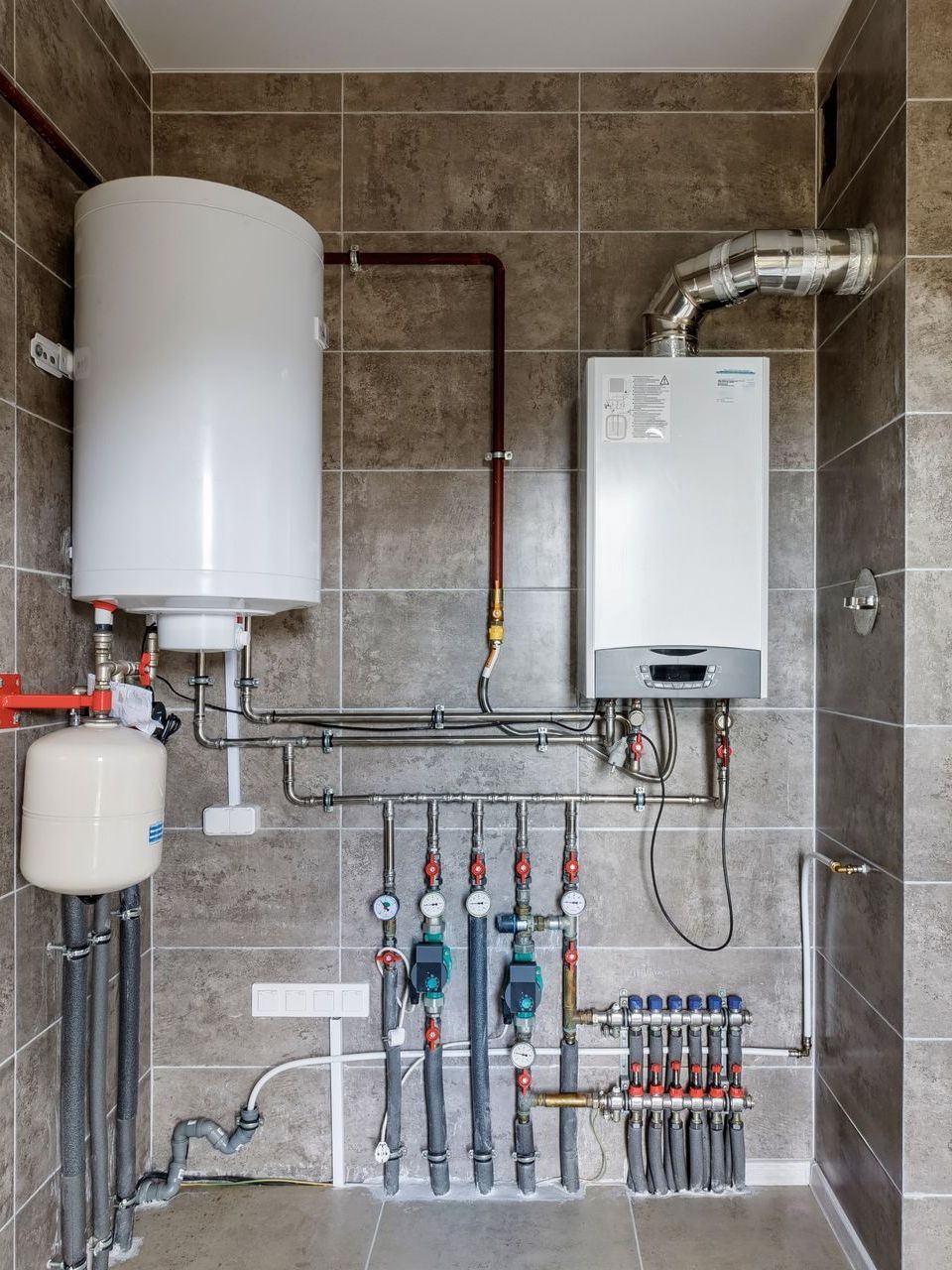 A room with a boiler and a water heater in it.