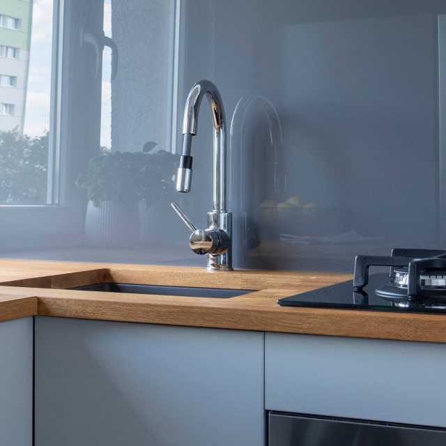A kitchen with a sink and a stove top oven