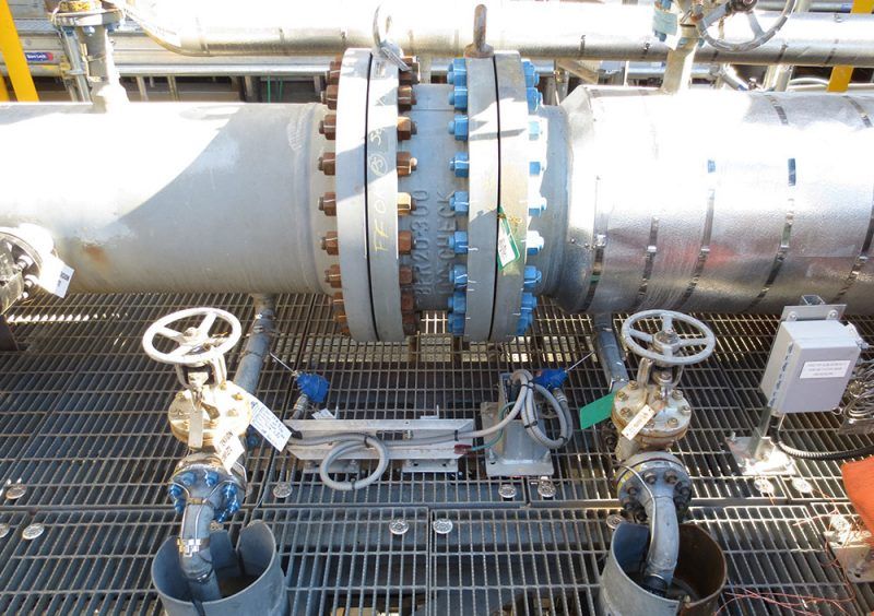 Industrial pipeline with two valves and a flange joint in a metal-grate facility setting