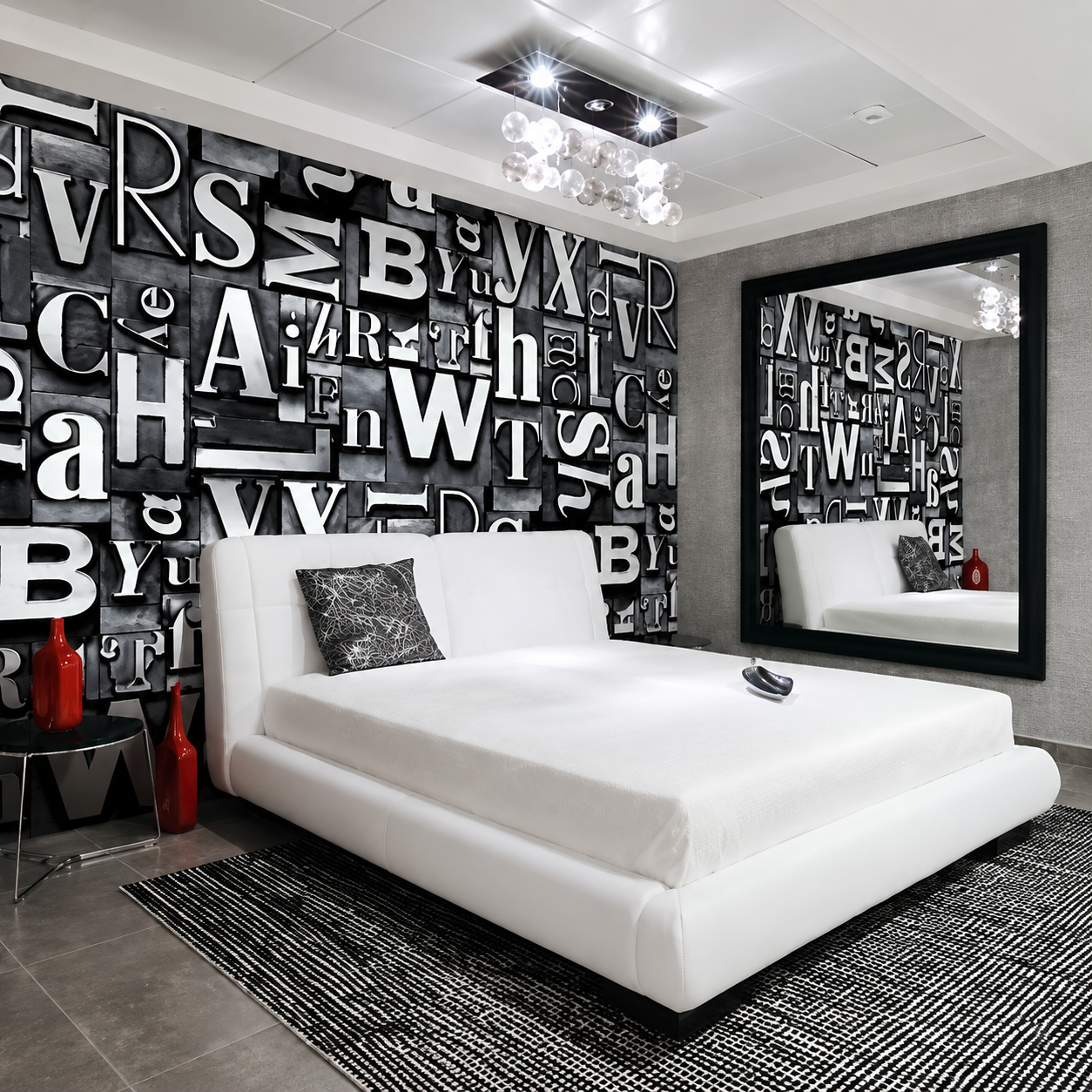 Camera da letto moderna in bianco e nero con carta da parati tipografica e un letto bianco di fronte a uno specchio.