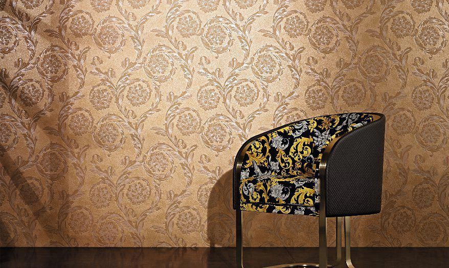Poltrona imbottita decorativa su carta da parati a motivi geometrici e pavimento in legno scuro.