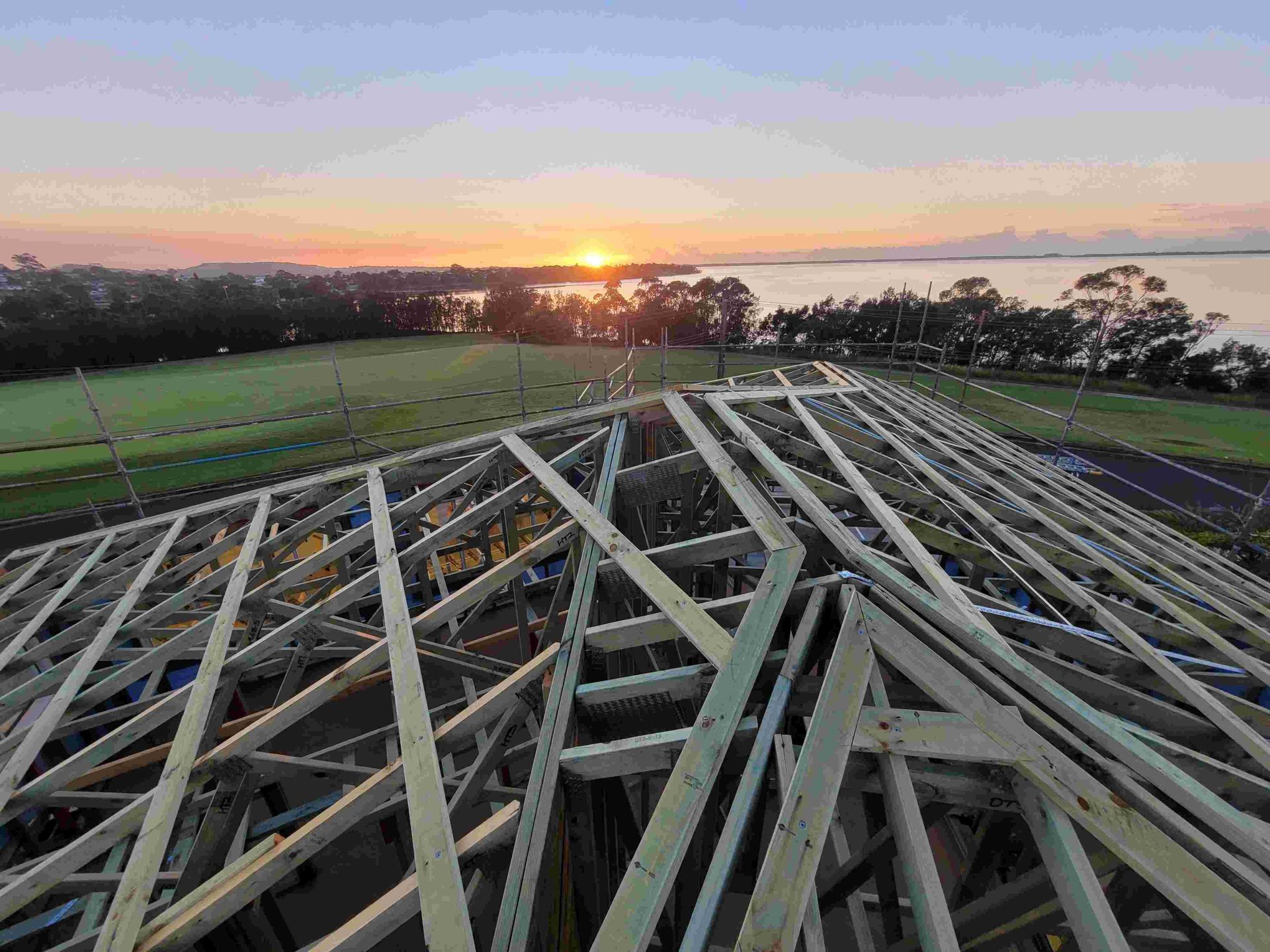 A Building Under Construction With a Sunset in the Background — GT Metal Roofing Solutions in Wollongong, NSW