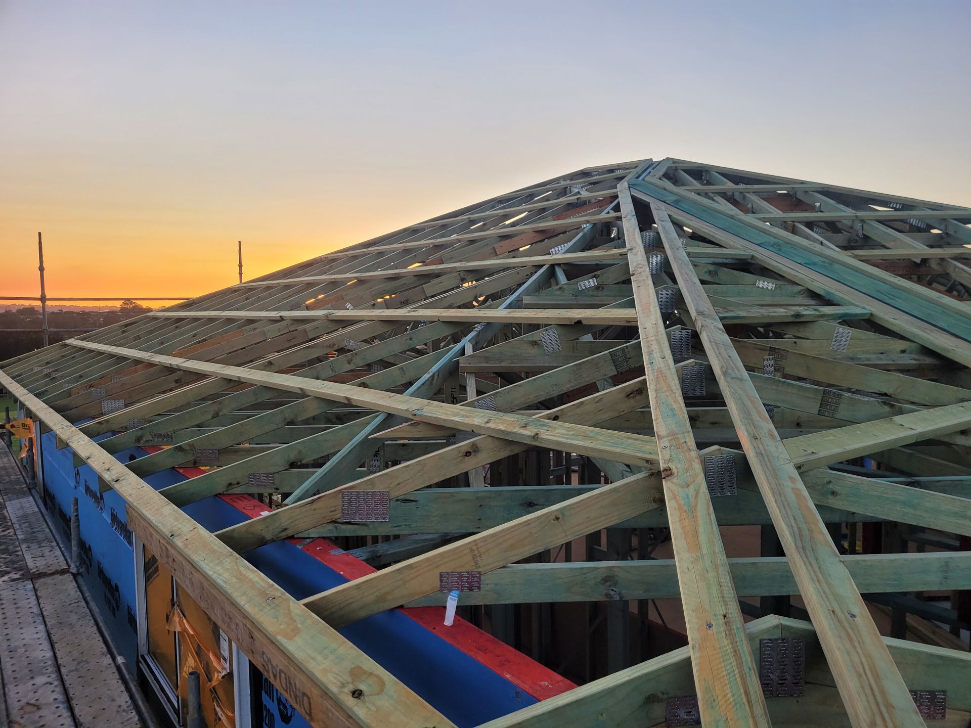 The Roof of a Building is Being Built With Wooden Beams — GT Metal Roofing Solutions in Wollongong, NSW  