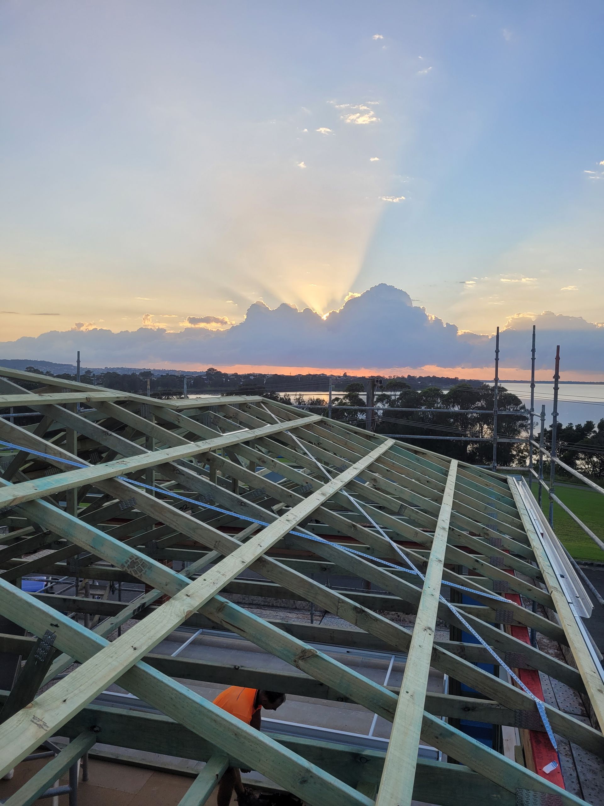 A Roof Under Construction With a Sunset in the Background — GT Metal Roofing Solutions in Wollongong, NSW 