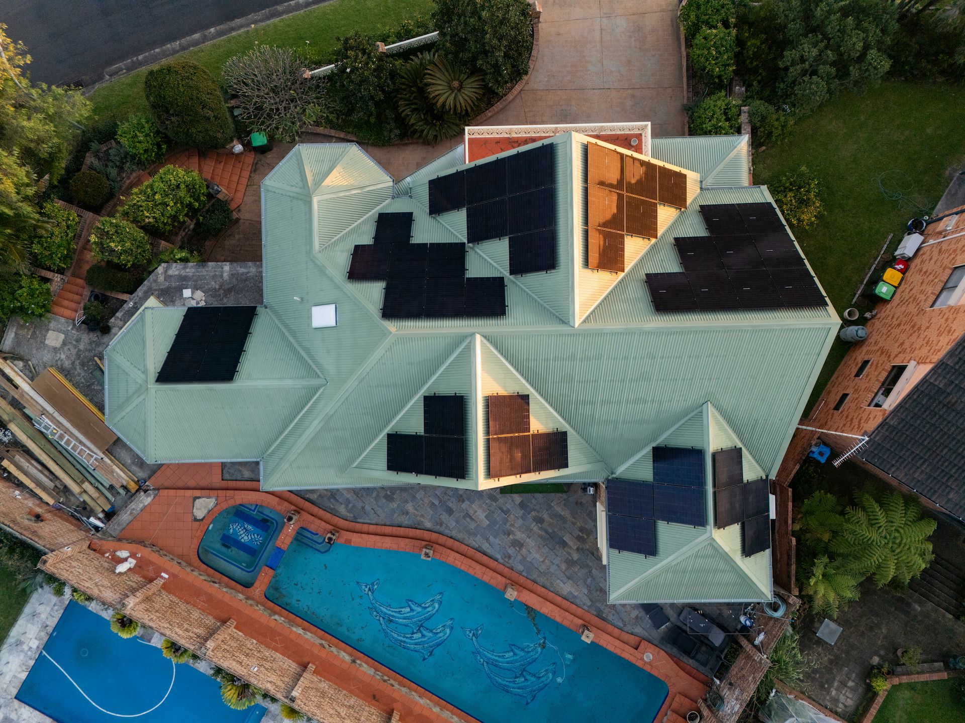 Aerial shot of a new green roof with solar panels and pool beside the house — GT Metal Roofing Solutions in Wollongong, NSW