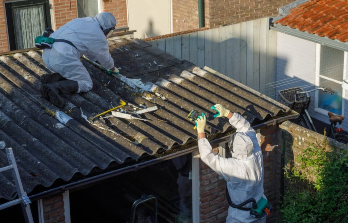 Two Men in Protective Suits Are Working on the Roof of a House — GT Metal Roofing Solutions in Shellharbour, NSW