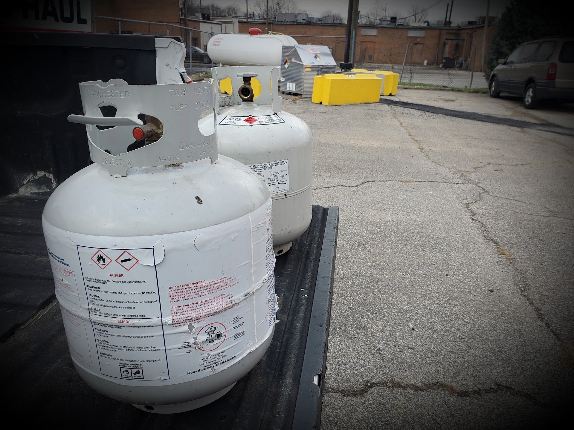 Two white propane tanks on a black trailer in an industrial lot | Lanning Automotive & Tire