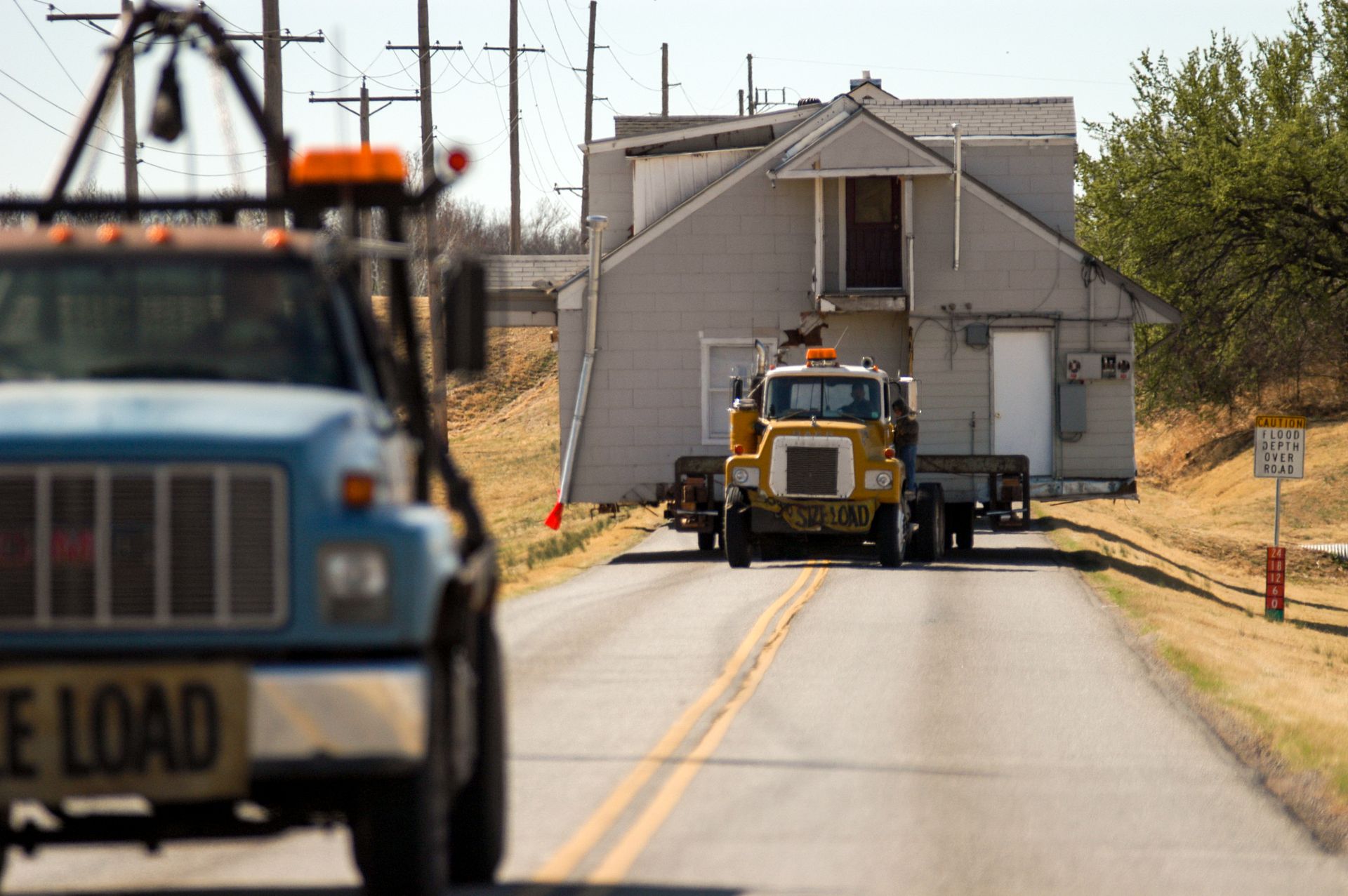 A truck is carrying a house.