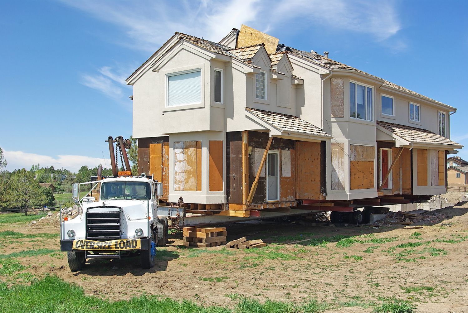 A house is being transported on a flatbed truck, showcasing the process of relocation.