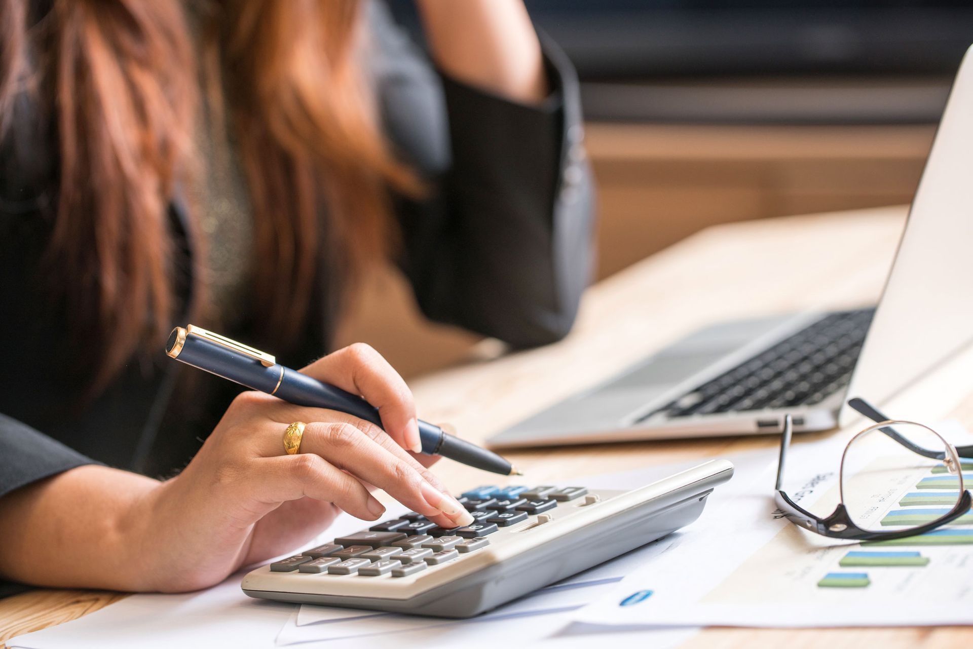 Woman Using A Calculator — Austin, TX — Rockstar Home Evaluation LLC