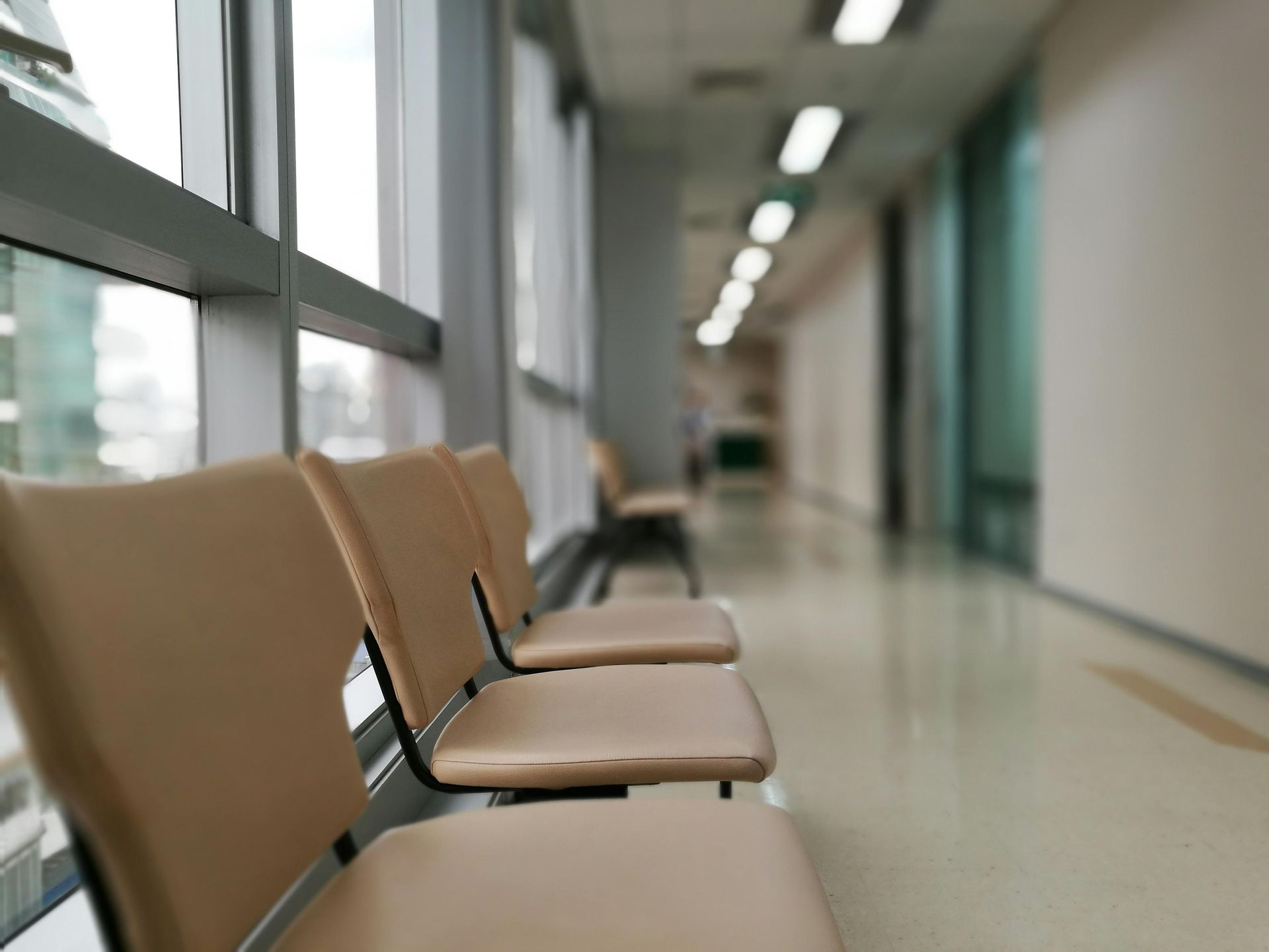 A row of chairs in a hallway in a hospital.