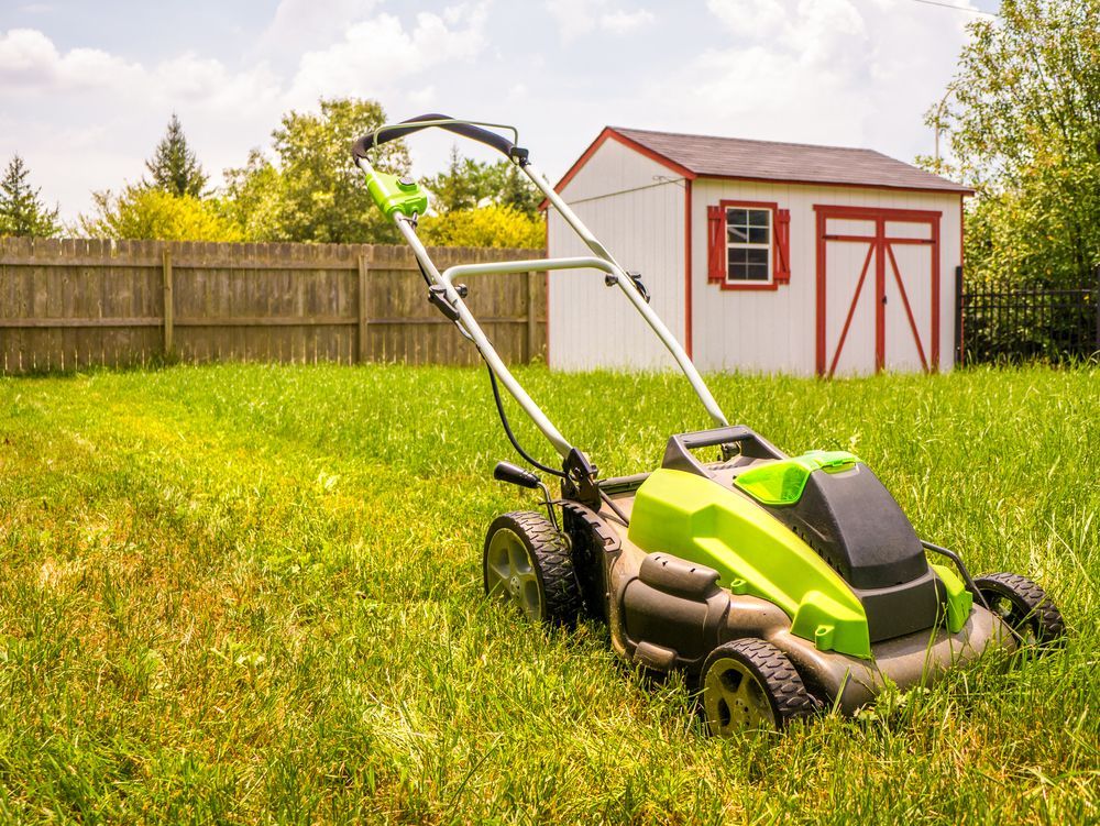 Green and Black Lawnmower Cutting Grass in a Yard — Hanta Mowing Services Townsville in Kirwan, QLD