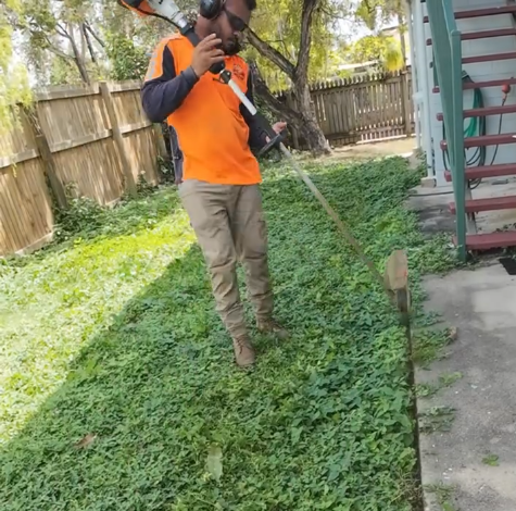Man in Overalls Laying Sod on a Sunny Day — Hanta Mowing Services Townsville in Kirwan, QLD