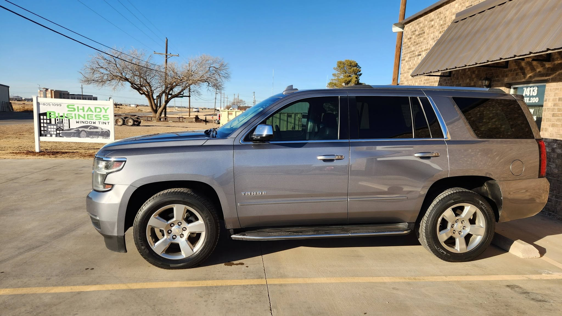 Silver SUV parked beside a building on a sunny street