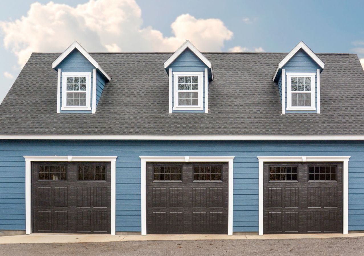 Two-story garage with three garage doors and a gray roof