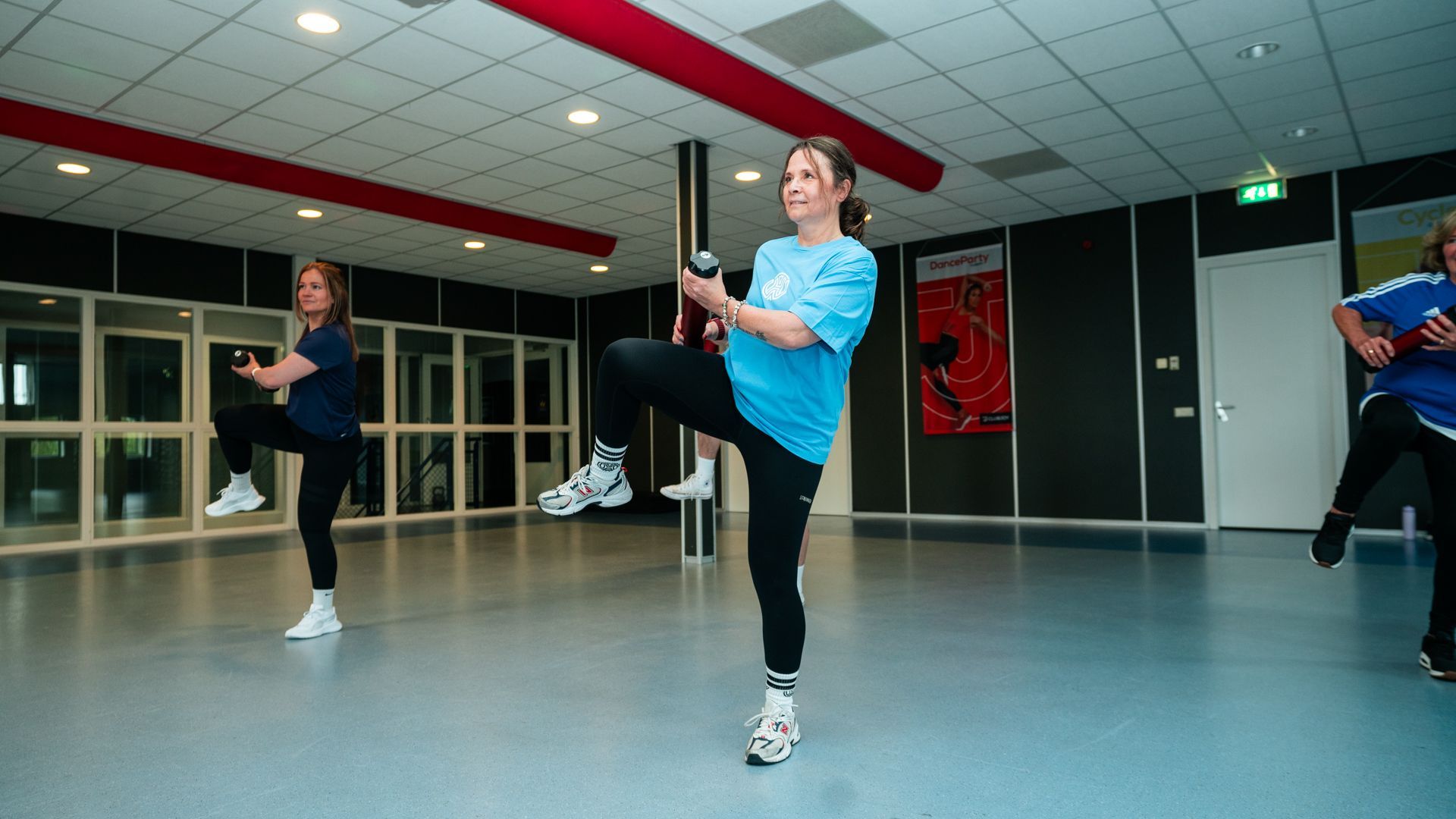 Vrouw in sportkleding doet dumbbell rows in de sportschool.