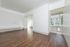 An empty living room with hardwood floors and white walls