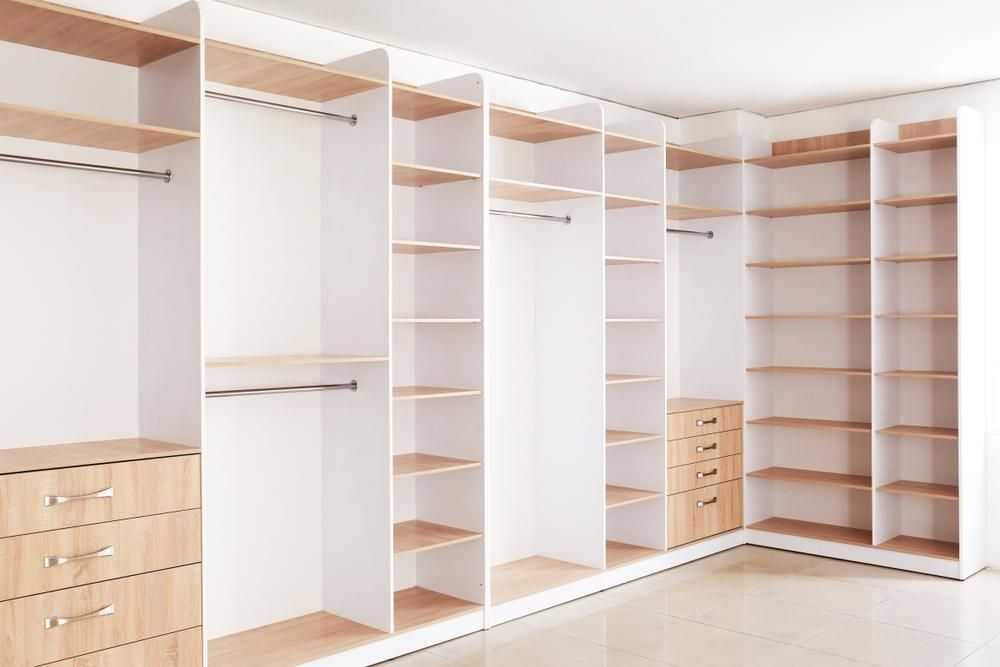 An Empty Walk in Closet With Lots of Shelves and Drawers — Mackay Cabinetmaking Service In Glenella, QLD