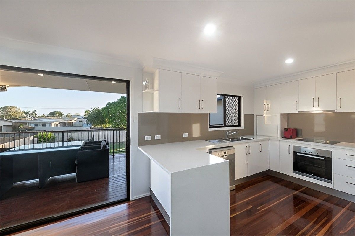 A Kitchen With a Sliding Glass Door Leading to a Balcony — Mackay Cabinetmaking Service In Glenella, QLD