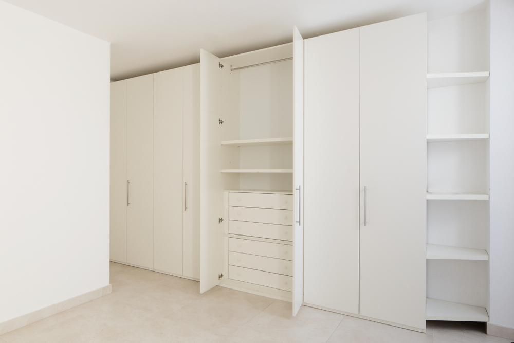 An Empty Room With White Cabinets and Shelves — Mackay Cabinetmaking Service In Glenella, QLD